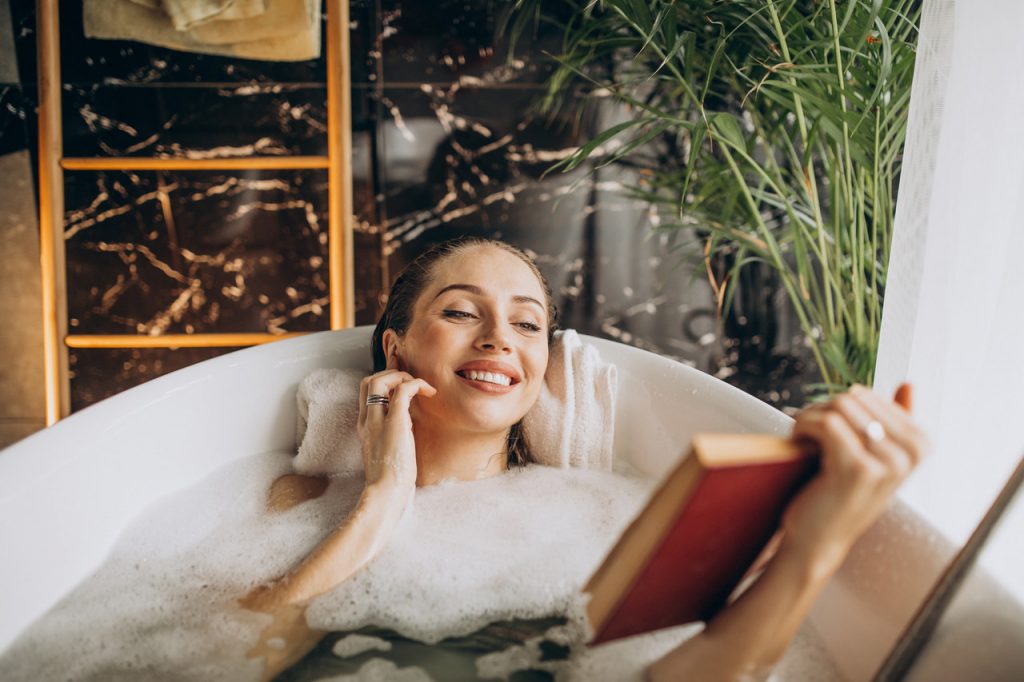 kobieta w czasie kąpieli czytająca książkę